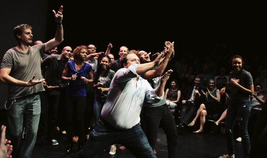 improv lesson teacher with kids on stage